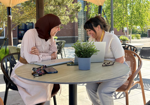 Naima en Gaezely lachend aan tafel